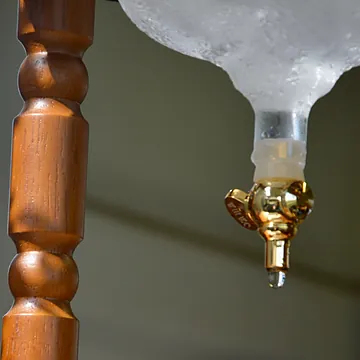 A drop falling from the brass tap of the cold drip tower
